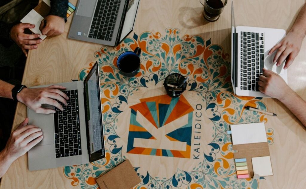 three laptops on a colorful table. 
