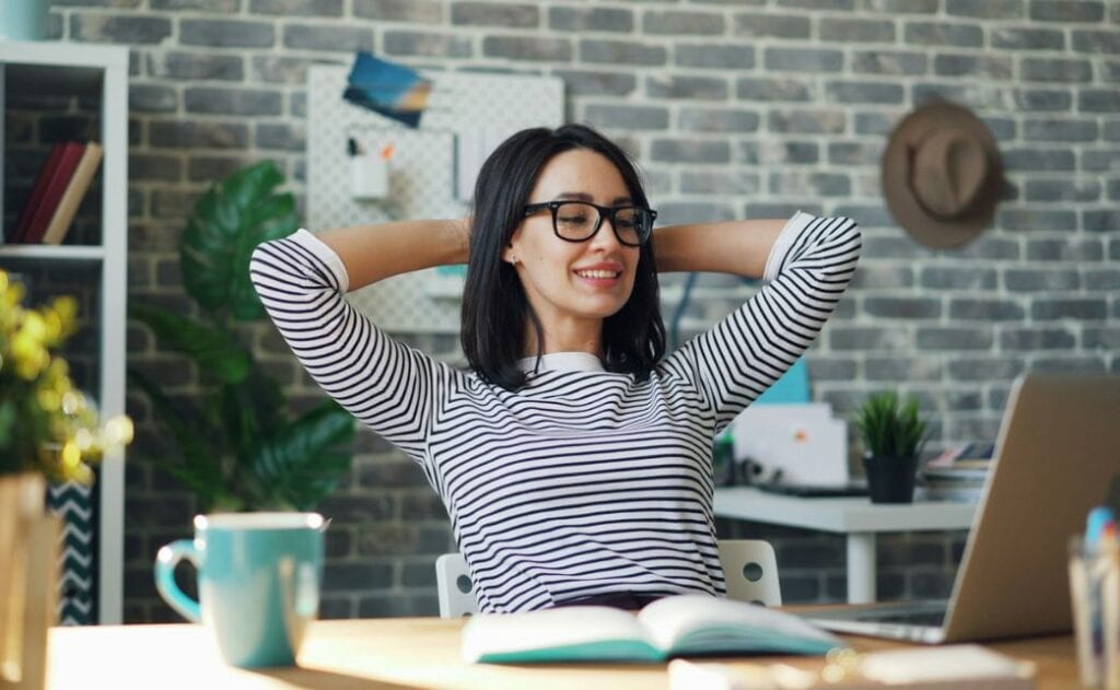 A femal sitting at a desk smiling. 